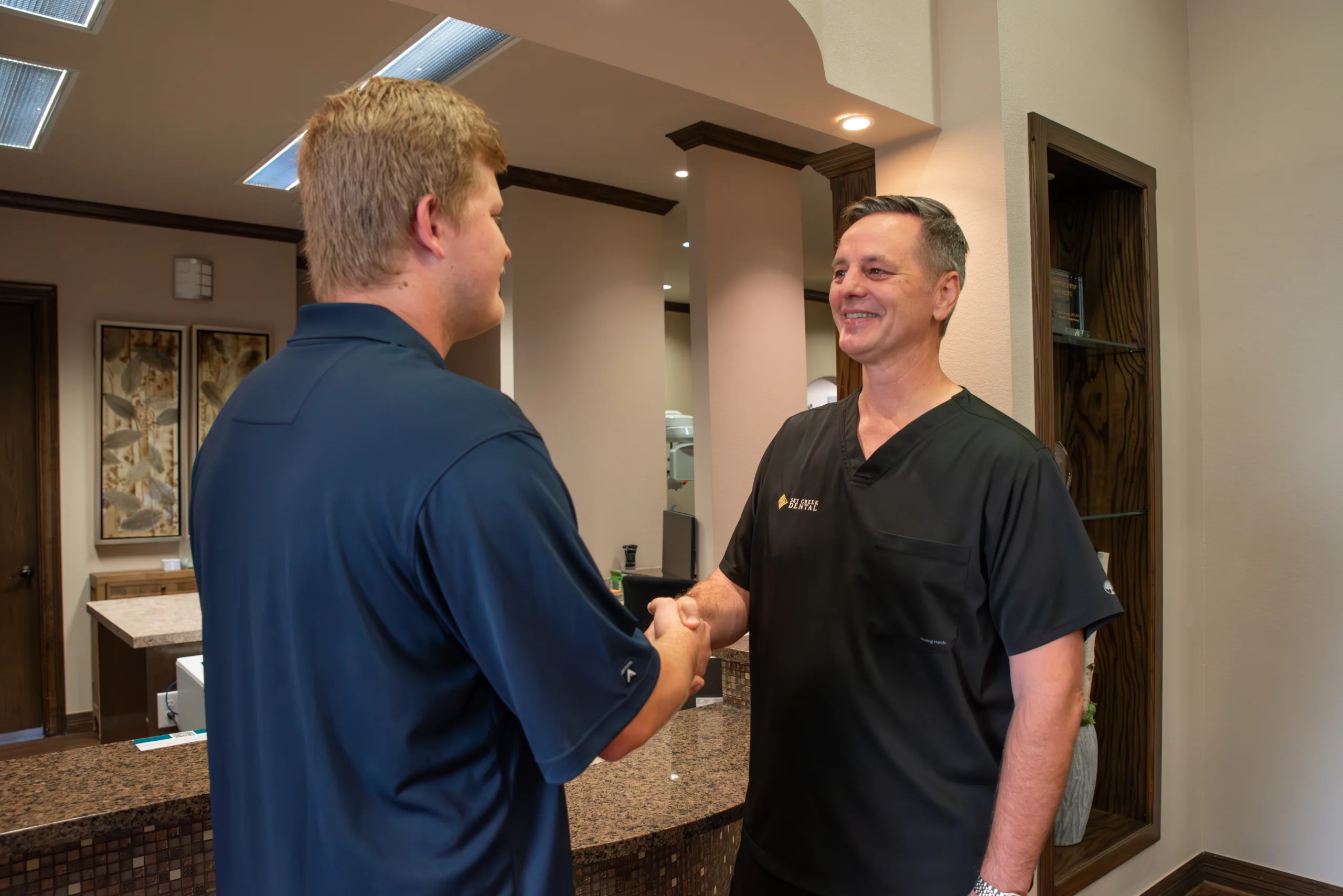 Keller dentist shaking hands with a patient at his dental office, Sky Creek Dental.
